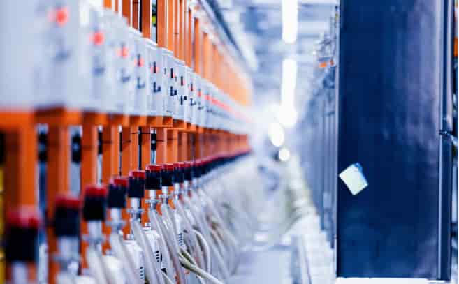 Blurred background shot of automated machinery or electrical cabinets in a modern factory, highlighting the repetitive structure and complexity of industrial wiring and components.