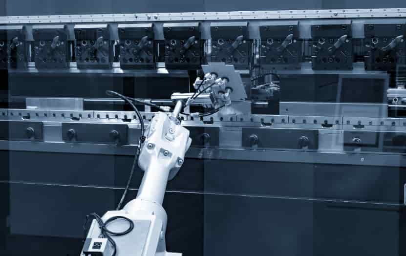Industrial robotic arm operating a metal sheet with a CNC press brake machine in an automated factory.